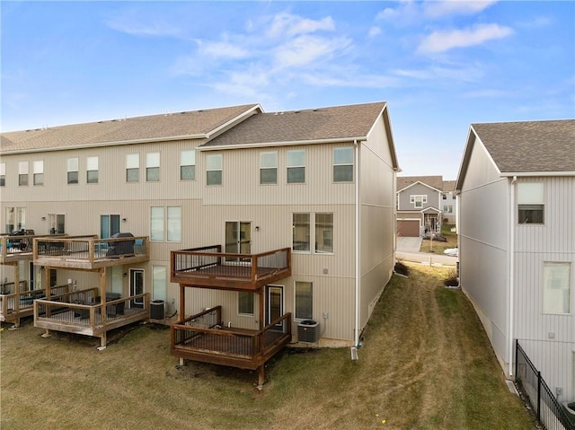 back of house featuring a deck, a yard, and central AC unit