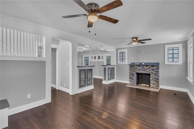 unfurnished living room with dark wood-type flooring, a fireplace, ornamental molding, and ceiling fan