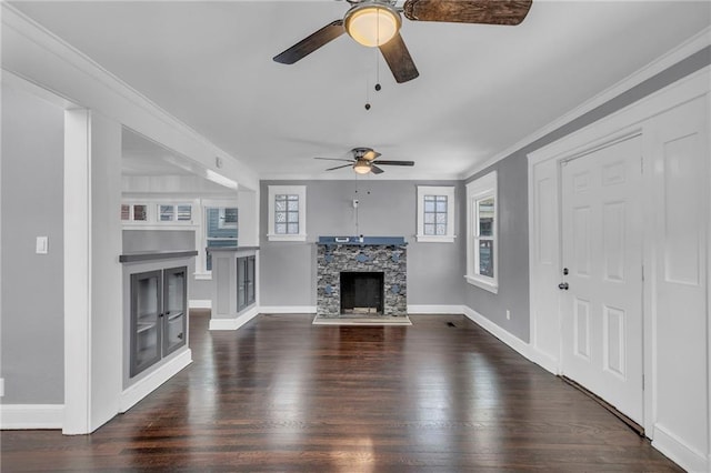 unfurnished living room featuring crown molding, ceiling fan, a stone fireplace, and dark hardwood / wood-style flooring