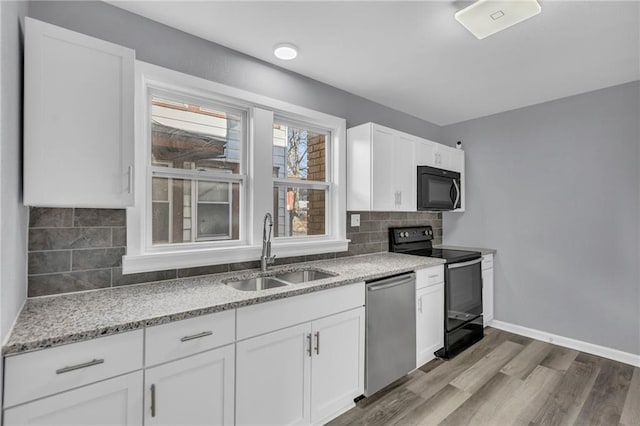 kitchen featuring sink, white cabinetry, black electric range, light wood-type flooring, and stainless steel dishwasher