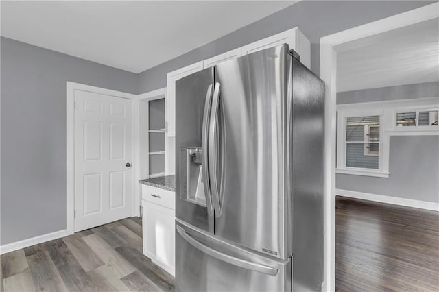 kitchen featuring dark stone countertops, stainless steel fridge with ice dispenser, dark wood-type flooring, and white cabinets