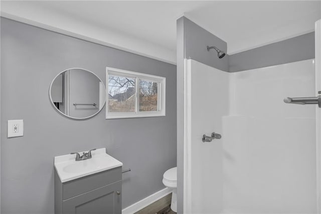 bathroom featuring vanity, walk in shower, and toilet