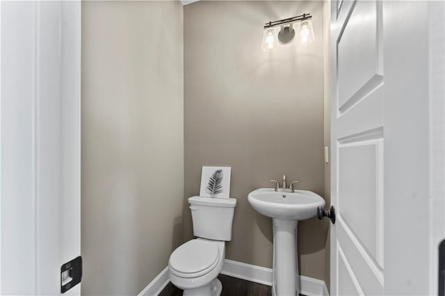 bathroom featuring sink, hardwood / wood-style floors, and toilet