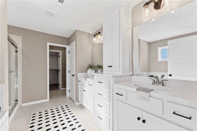 bathroom featuring vanity, a shower with door, and tile patterned flooring