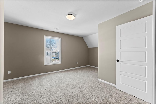 bonus room with vaulted ceiling and carpet