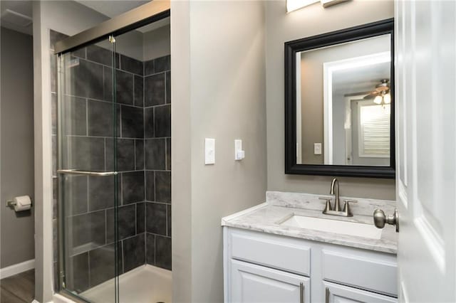 bathroom with vanity, an enclosed shower, and ceiling fan