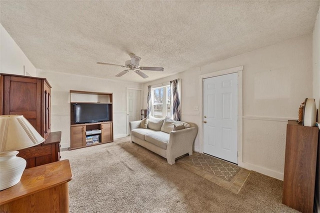 living room with ceiling fan, carpet floors, and a textured ceiling