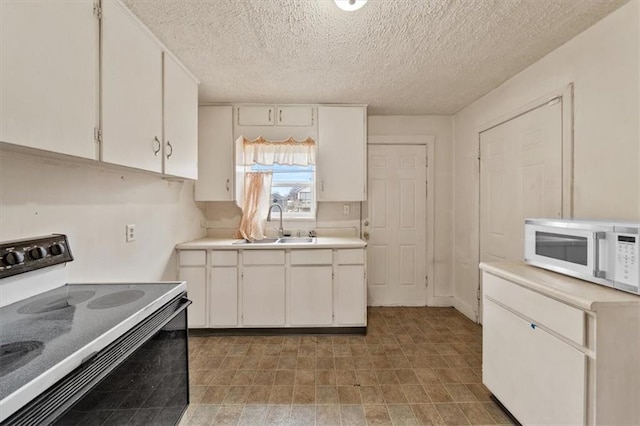 kitchen featuring white cabinetry, sink, and range with electric stovetop