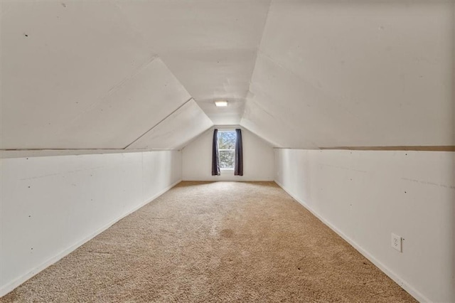 bonus room with carpet floors and vaulted ceiling