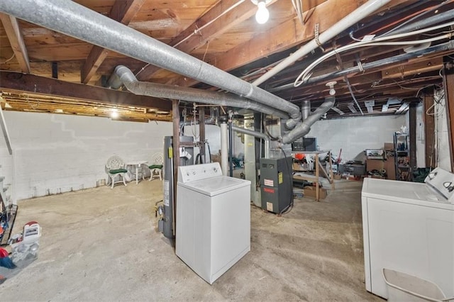 basement featuring gas water heater, heating unit, and washing machine and dryer