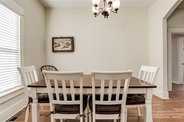 dining area with plenty of natural light, light wood-type flooring, and a chandelier