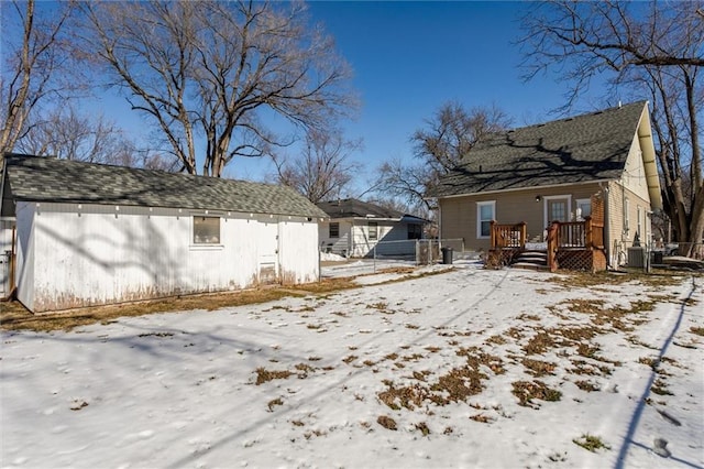 snow covered house featuring central AC