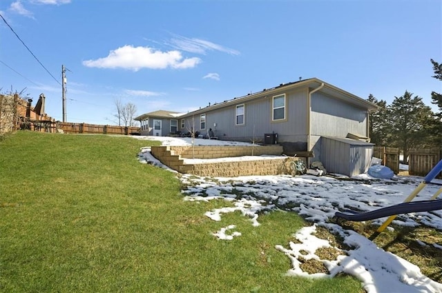 snow covered house featuring a lawn