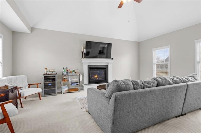 carpeted living room with vaulted ceiling, beverage cooler, and ceiling fan