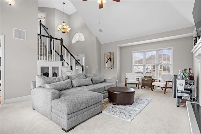 carpeted living room with ceiling fan with notable chandelier, a fireplace, and high vaulted ceiling