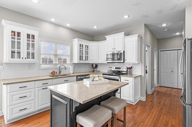 kitchen featuring white cabinetry, sink, a center island, and appliances with stainless steel finishes