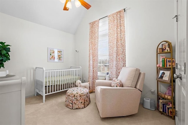 carpeted bedroom featuring vaulted ceiling, a nursery area, and ceiling fan