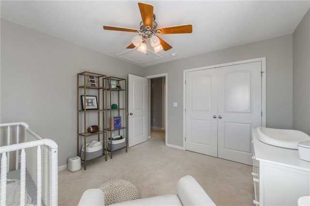 bedroom with light colored carpet, ceiling fan, and a closet