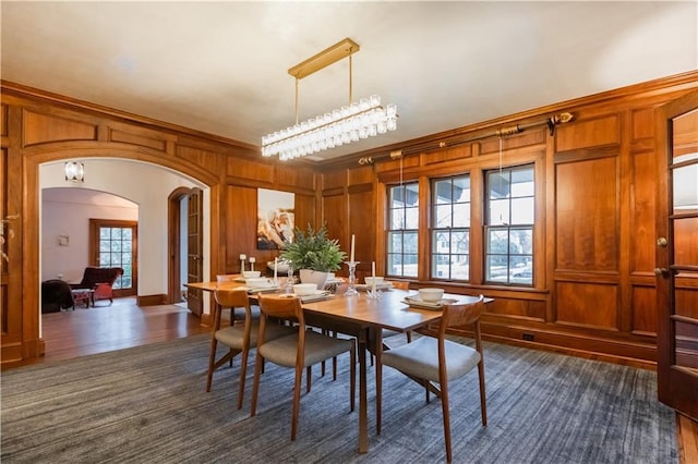 dining room featuring wooden walls and ornamental molding