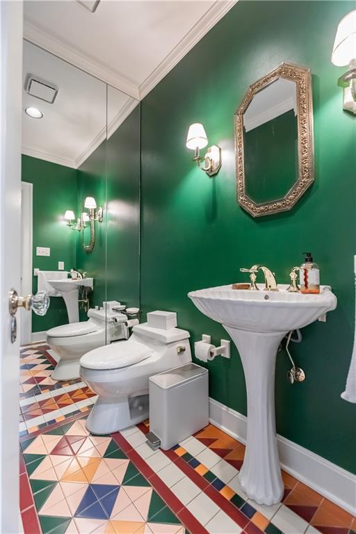 bathroom with a bidet, tile patterned floors, crown molding, and toilet