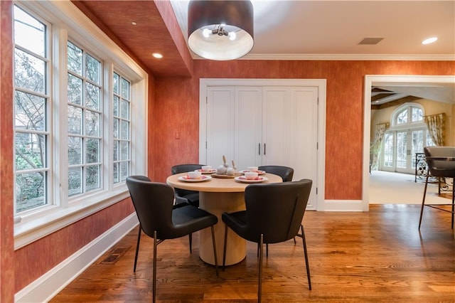 dining area with hardwood / wood-style flooring and ornamental molding