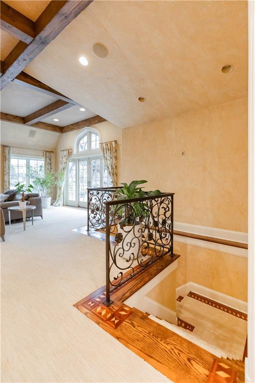 hallway with carpet floors and beam ceiling