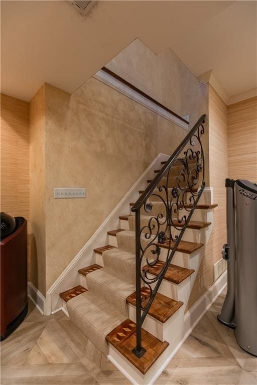 staircase featuring parquet flooring and ornamental molding