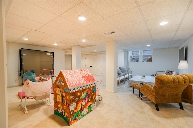 playroom featuring light carpet and a drop ceiling