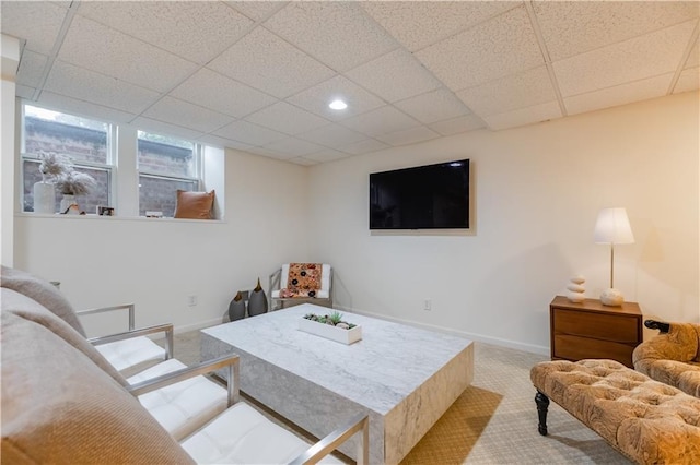 carpeted living room featuring a paneled ceiling