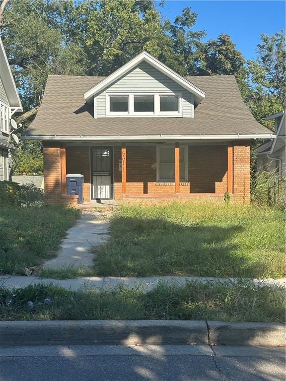 view of front of house with covered porch and a front lawn