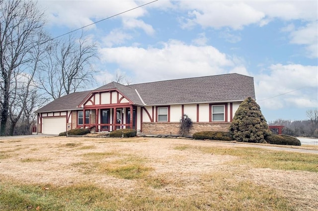 tudor house with a garage and a front yard