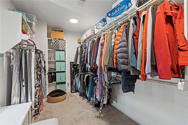 walk in closet with visible vents and carpet