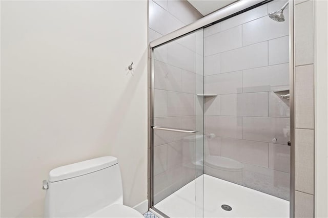 bathroom featuring a stall shower and toilet
