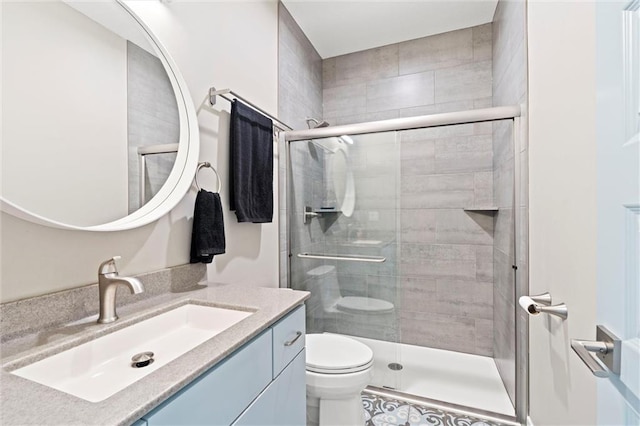 bathroom featuring toilet, a tile shower, and vanity