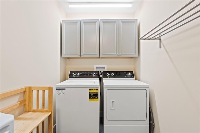 washroom featuring washer and clothes dryer and cabinet space