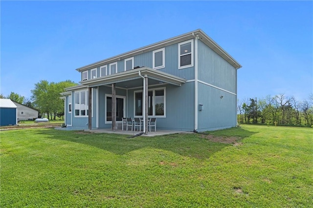 rear view of house with a lawn and a patio