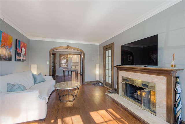 living room featuring hardwood / wood-style floors, crown molding, and a premium fireplace