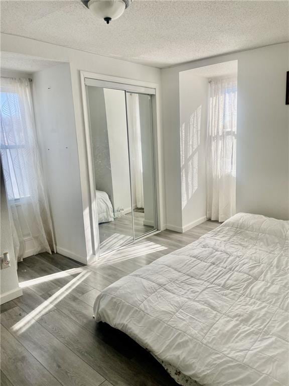 bedroom with hardwood / wood-style flooring, a closet, and a textured ceiling