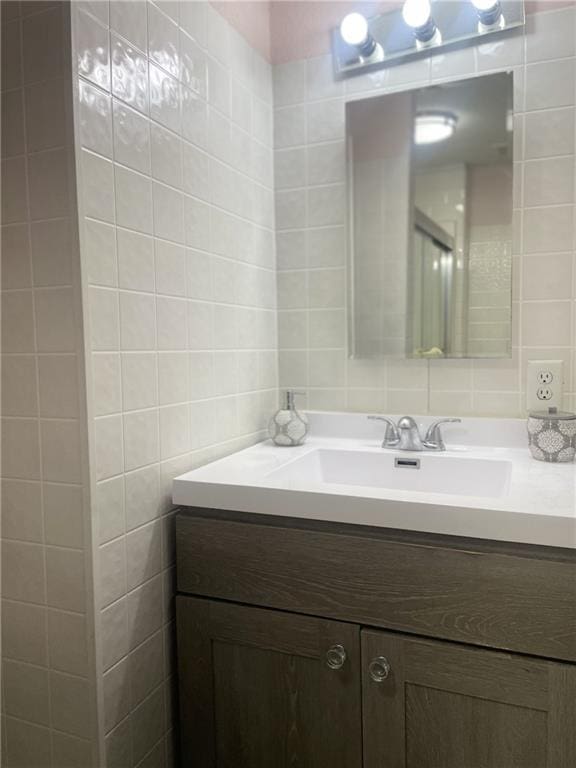 bathroom featuring vanity and tile walls