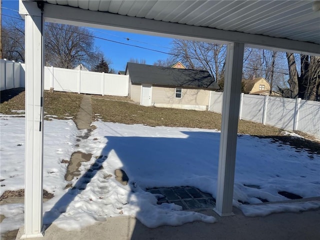 yard covered in snow featuring a storage shed