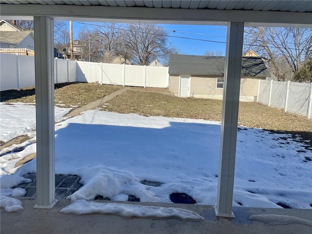 yard covered in snow with a storage unit