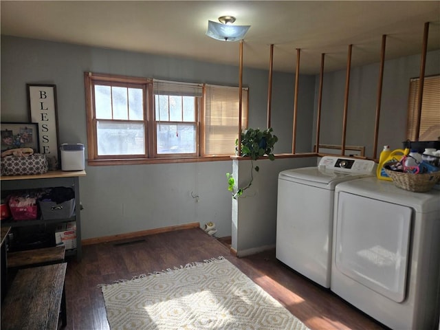 clothes washing area with dark wood-type flooring and washer and dryer