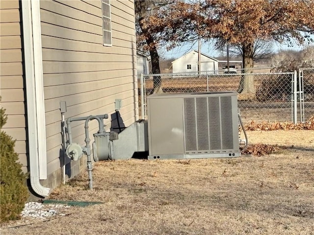 view of yard featuring a gate, fence, and central AC unit