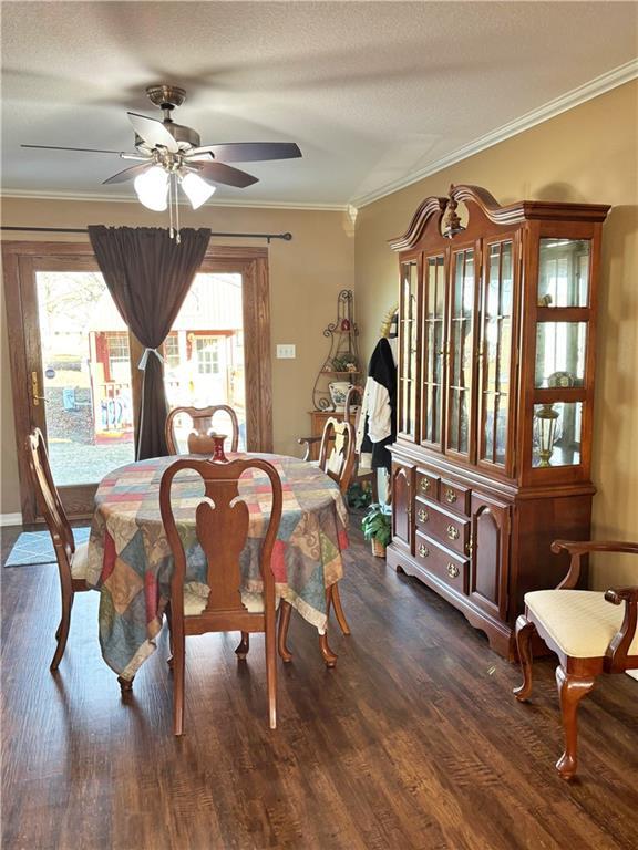 dining space featuring ceiling fan, ornamental molding, and dark wood-style flooring