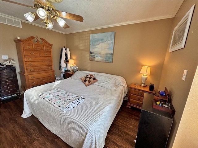 bedroom featuring ceiling fan, visible vents, crown molding, and wood finished floors