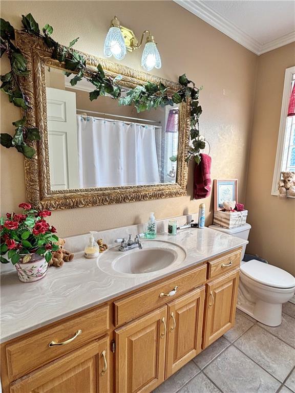 bathroom with toilet, ornamental molding, vanity, a shower with curtain, and tile patterned floors