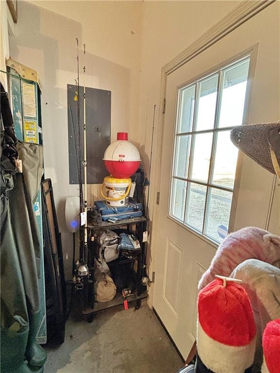 doorway to outside with electric panel and concrete flooring