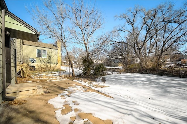 yard covered in snow featuring a patio area