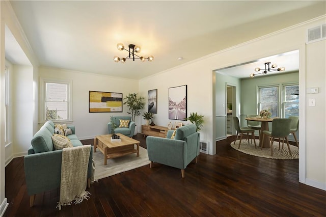 living room with crown molding, dark hardwood / wood-style flooring, and a notable chandelier