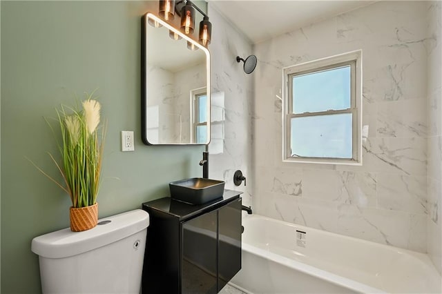 full bathroom featuring tiled shower / bath, vanity, and toilet